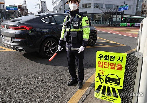 운전자가 교차로에서 우회전할 때 일시 정지해야 하는 개정 도로교통법이 시행된 1년 동안 우회전 교통사고가 약 8.4% 감소한 것으로 나타났다. 지난 1월 19일 서울 강서구 한 교차로에서 경찰이 우회전 일시 정지 계도 및 단속 활동을 벌이고 있다. [연합뉴스]